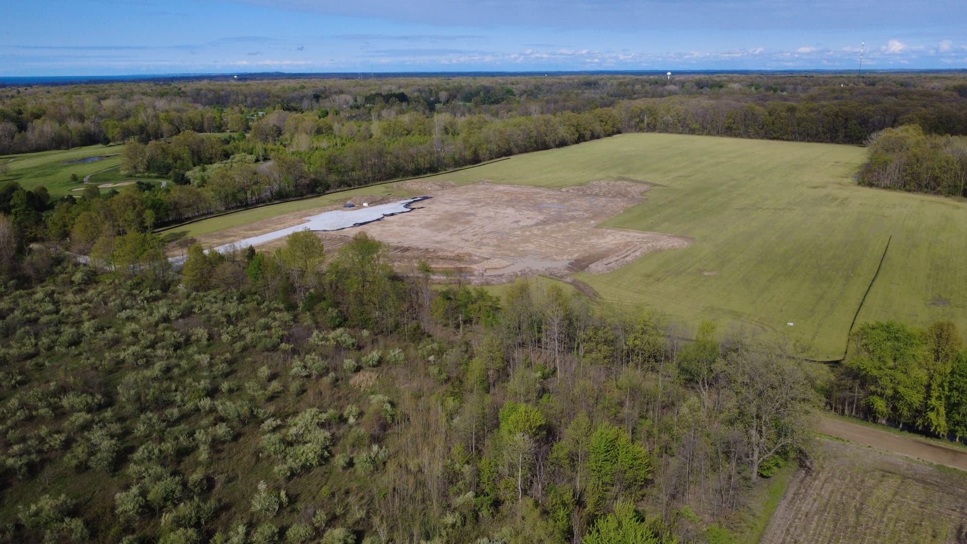 Aerial view of the Kluver Road parcel on May 1, 2026 — a small cleared and graded patch