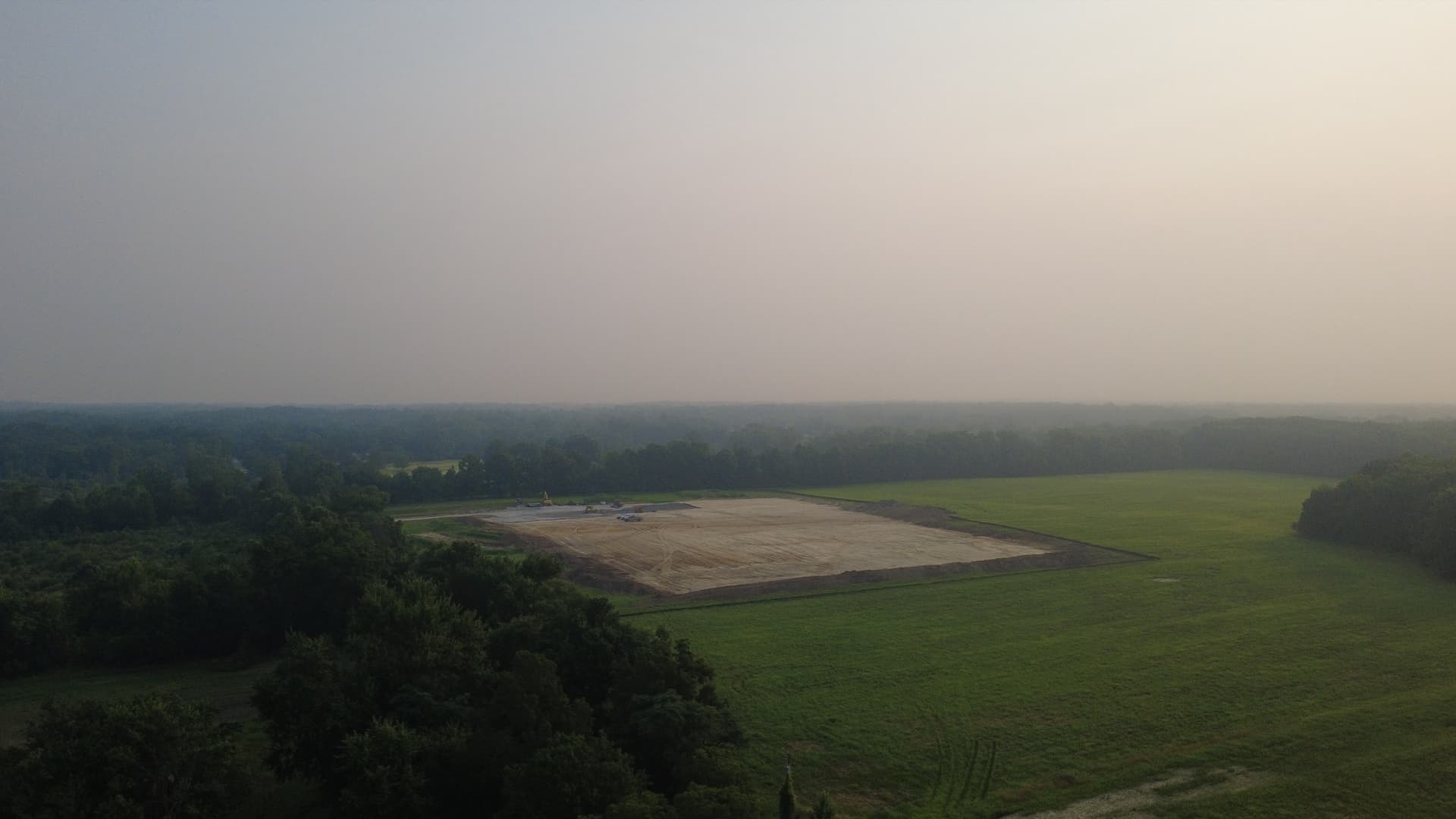 Aerial view of the Kluver Road parcel on July 16, 2026 — a large graded construction pad