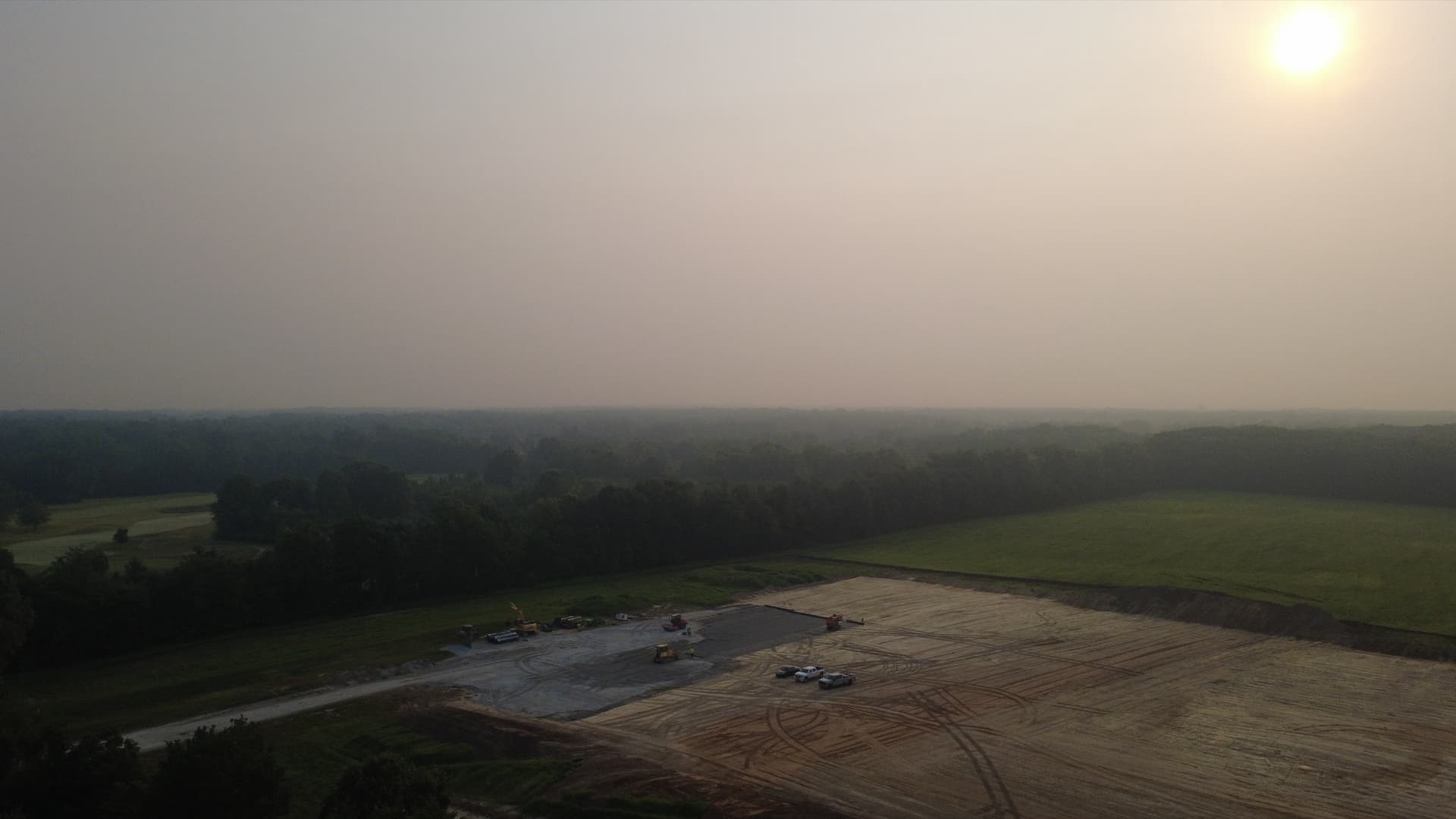 Aerial view of the Kluver Road parcel on July 16, 2026 — heavy equipment working the graded pad
