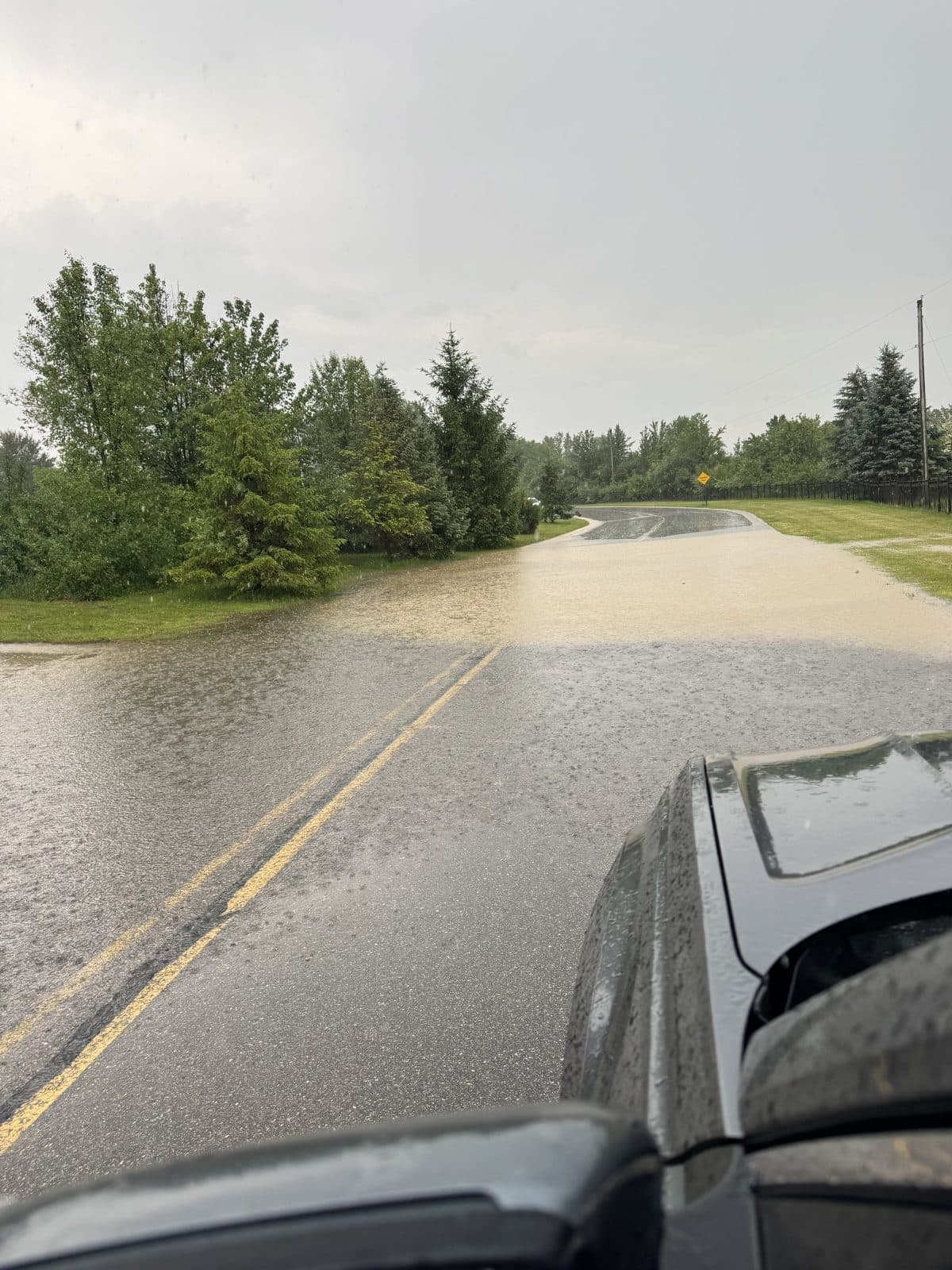 Kluver Road submerged under muddy stormwater runoff
